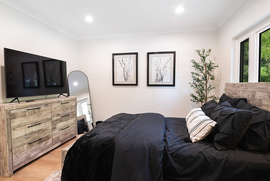 The garden-view bedroom from the other side, showing its dresser, TV and mirror